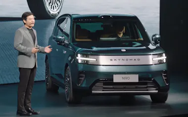 小米にとって初めてのPHV「スカイノマド」と発表会に登壇した雷軍CEO㊧(30日、同社SNSから)