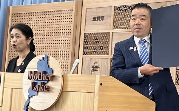26日、滋賀県庁で記者会見する三日月大造知事㊨