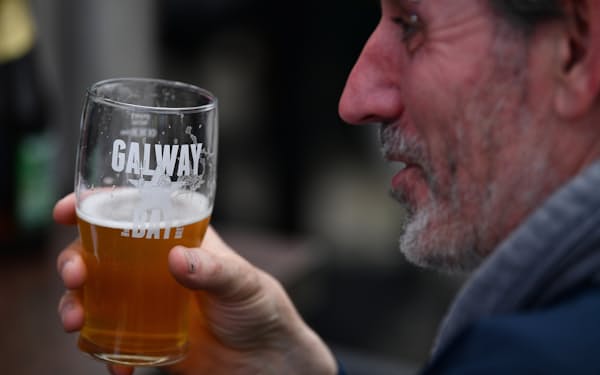 アイルランド西部ゴールウェイの街でビールを飲む男性（2021年6月）=ロイター