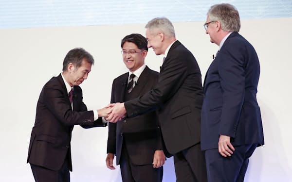 握手する日野の小木曽社長㊧と三菱ふそうのカール・デッペン社長兼CEO(30日)