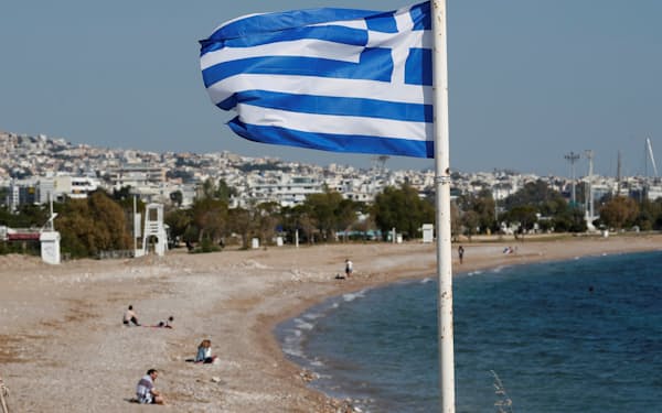 A Greek national flag flutters as people visit a beach, following the coronavirus disease (COVID-19) outbreak, in Athens, Greece, April 28, 2020. Picture taken April 28, 2020. REUTERS/Goran Tomasevic - RC2CEG9A6RJK