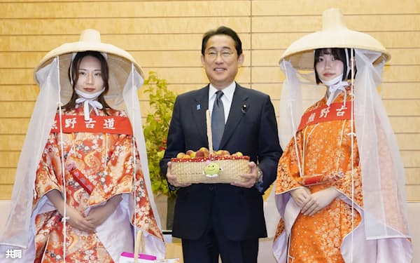和歌山県産の梅をPRする「梅娘」の表敬を受けた岸田首相(6日午後、首相官邸)=共同