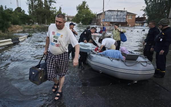 ダム決壊による洪水で避難する市民（６日、ウクライナ南部ヘルソン州）=AP