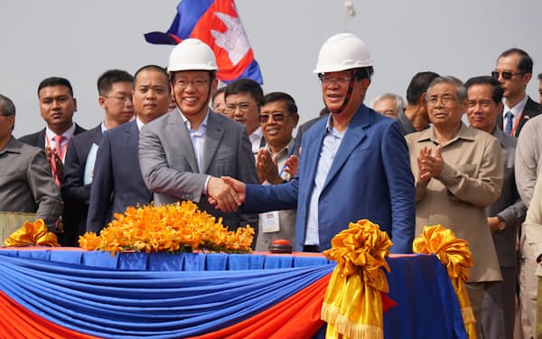 ７日の起工式で握手するフン・セン首相（写真右）と王文天駐カンボジア中国大使