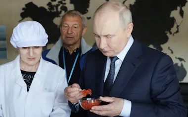 択捉島の水産加工施設を視察し、製品を試食するロシアのプーチン大統領=AP