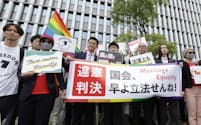 同性婚を巡る福岡地裁判決を受け横断幕を掲げる原告ら=8日午前、福岡市、共同