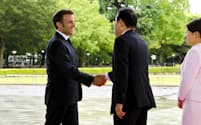 ５月19日、広島市で岸田文雄首相と握手するフランスのマクロン大統領（左）