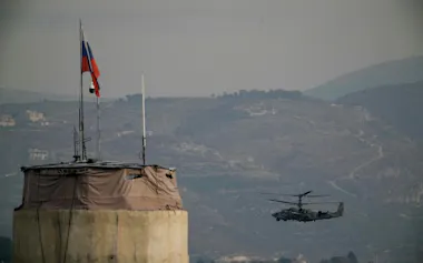 シリア国内にあるヘメイミーム空軍基地上空を飛行するロシア軍のヘリコプター=AP