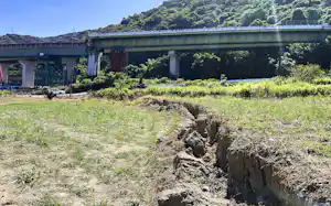 畑に現れた断層。割れ目の奥には損傷した南九州自動車道が見える(熊本県八代市) 畑に現れた断層。割れ目の奥には損傷した南九州自動車道が見える(熊本県八代市)