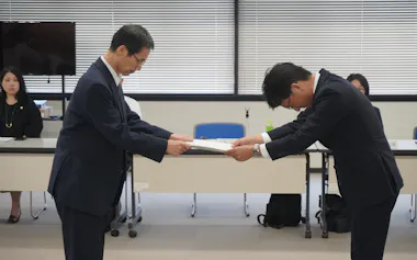 審議会の深浦厚之会長(左)から長崎労働局の高西盛登局長に答申した(28日、長崎市)