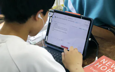 英語の授業で生成AIアプリを使って自ら作った英文の発音などを確認する中学生(7月、画像の一部を加工しています)=共同