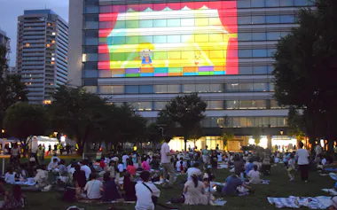 ビルの壁面に映画を映して芝生の上で鑑賞した(8月、東京都中野区)