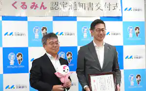 「くるみん」の認定通知書を受け取った宮崎銀行の湯川人事部長㊨と、宮崎労働局の吉越局長(4日、宮崎市) 「くるみん」の認定通知書を受け取った宮崎銀行の湯川人事部長㊨と、宮崎労働局の吉越局長(4日、宮崎市)