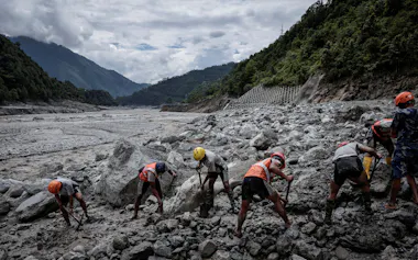 洪水被害を受けた水力発電所でがれき除去作業にあたる救助隊(3日)=ロイター