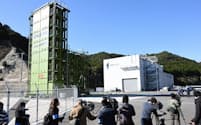 報道陣に公開された民間ロケット発射場「スペースポート紀伊」の打ち上げ射点（左）と組み立て施設（2022年12月、和歌山県串本町）