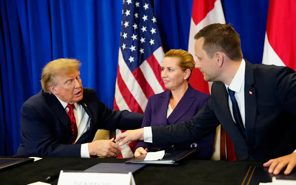署名式に出席したトランプ米大統領㊧とデンマークのフレデリクセン首相㊥、グリーンランド自治政府のニールセン首相㊨(22日、ニューヨーク)=ロイター