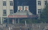北朝鮮北部の都市、新義州の街頭に並ぶ金日成氏と金正日氏の肖像（2023年６月、中国の遼寧省丹東市から撮影）