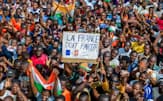 ニジェールの首都ニアメーでは「フランスは出ていけ」と書かれた段ボールを掲げたデモ参加者もいた=ロイター