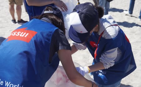 稲毛海浜公園(千葉市)でペットボトル回収などの海岸クリーンアップ作業に取り組むニッスイの従業員と家族（7月29日）