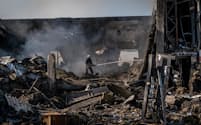 ロシアの攻撃で破壊された建物で消火活動に当たる消防士(15日、クラマトルスク)=ゲッティ・共同