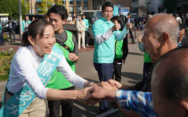 選挙期間中に支持者と握手をする原沢氏㊧(17日、横浜市)
