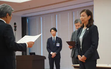 横浜市選管から当選証書を受け取る原沢市長㊨(19日、同市役所)