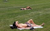 金曜日に米ニューヨークのセントラルパークで日光浴をする人（7月28日）=ロイター