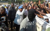 トゥアデラ大統領（中央）の前で護衛に当たる目出し帽姿のワグネルの戦闘員（７月、中央アフリカ共和国の首都バンギ）＝ロイター