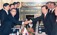 日韓首脳会談の全体会合で握手する小渕首相（左）と金大中・韓国大統領（1998年10月、東京・元赤坂の迎賓館。代表撮影）