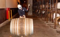 ウイスキー樽の栓をたたいて抜き、原酒サンプルを取り出す工程を見学できる（10日、大阪府島本町）