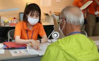 町民は健診後、専門スタッフ㊧から保健指導を受けられる(7月、久山町提供)