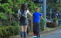 街中で電動キックボードに乗る人たち。交通ルールやマナーを守って利用したい（都内）