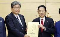 自民党の経済対策の提言を萩生田政調会長（左）から受け取る岸田首相（17日、首相官邸）