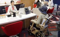 JALのスペシャルアシスタンスカウンターでは、高齢者などへのお手伝いをする（羽田空港）