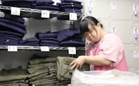 清掃会社でスタッフのユニホームを片付ける吉井彩香さん