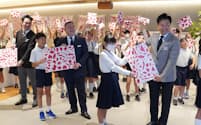 小学生がデザインした包装紙を銀座三越の店長らに手渡した（２５日、東京都中央区）