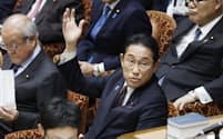 衆院予算委で答弁のため挙手する岸田首相（27日）