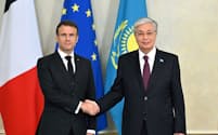 １日、アスタナでの首脳会談で握手するトカエフ・カザフスタン大統領㊨とマクロン仏大統領（カザフスタン大統領府提供）＝ロイター