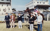 馬選びはだいたい調教師に任せていた。京都競馬場でメイショウハッピーと（1978年、松本会長は左から３番目）