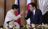 夕食会でフィリピンのマルコス大統領（左）と乾杯する岸田首相＝3日、マニラ（共同）