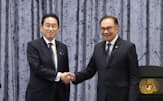 共同記者発表を終え握手するマレーシアのアンワル首相（右）と岸田首相=共同