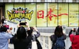 阪神タイガースが日本一となり、百貨店のディスプレーを写真に収める人たち（6日午前、大阪市北区の阪神梅田本店）