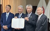 和歌山県庁で署名した協定書を示す岸本周平知事㊧、トーヨーカネツの大和田能史社長（左から2人目）ら関係者（8日）