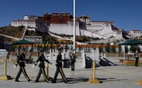 チベット自治区の区都ラサで世界遺産のポタラ宮の前を行進する警察官（2020年）＝ロイター