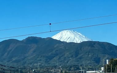 時折入る寒気の影響で雪をいただいた富士山（19日、神奈川県側から）