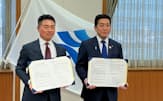 協定書を持つPwCコンサルティングの大竹伸明CEO（左）と塩田康一鹿児島県知事（22日、鹿児島県庁）