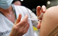 新型コロナウイルスのワクチン接種を受ける患者＝ロイター
