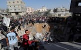 イスラエルによる空爆を受けた現場に集まり犠牲者を捜索する人々（23日、ガザ南部ラファ）=ロイター