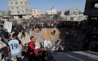 イスラエルによる空爆を受けた現場に集まり犠牲者を捜索する人々（23日、ガザ南部ラファ）＝ロイター
