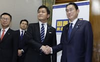 23年度補正予算案に賛成票を投じた国民民主党の玉木代表（中）と握手を交わす岸田首相（24日）